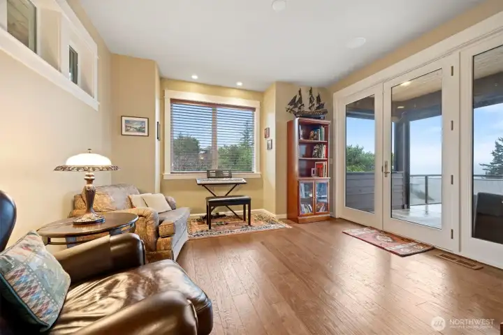 The library is beyond the kitchen at the south-end of the main floor, and it takes in the stunning views as well. It opens to the wrap-around deck and has a covered area designed for barbequing (gas is piped for that), and sitting/dining.