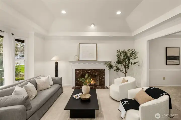 Living room with tray ceiling has gas fireplace