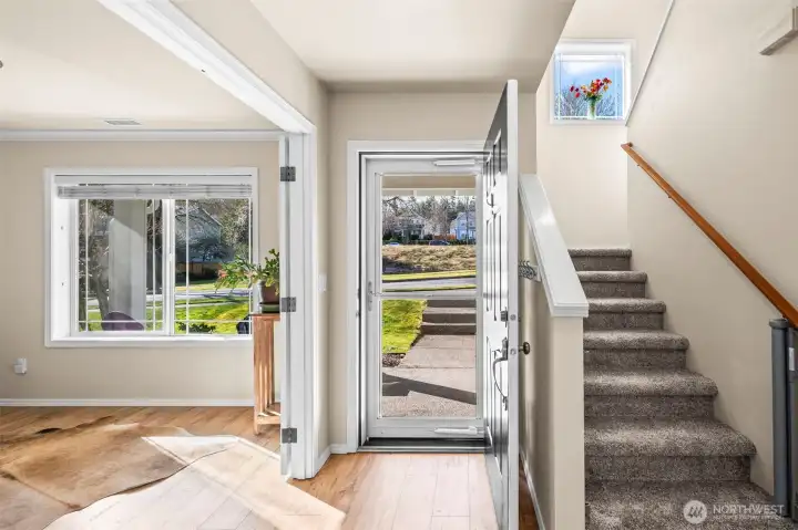 Storm doors on the front and back provide additional light and options for airflow. The room to the left of the entry is the den/office with French doors and a large window with 2-inch, white blinds.