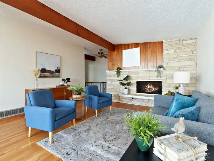 Spacious living room with gas fireplace, hardwood floors, vaulted ceiling.