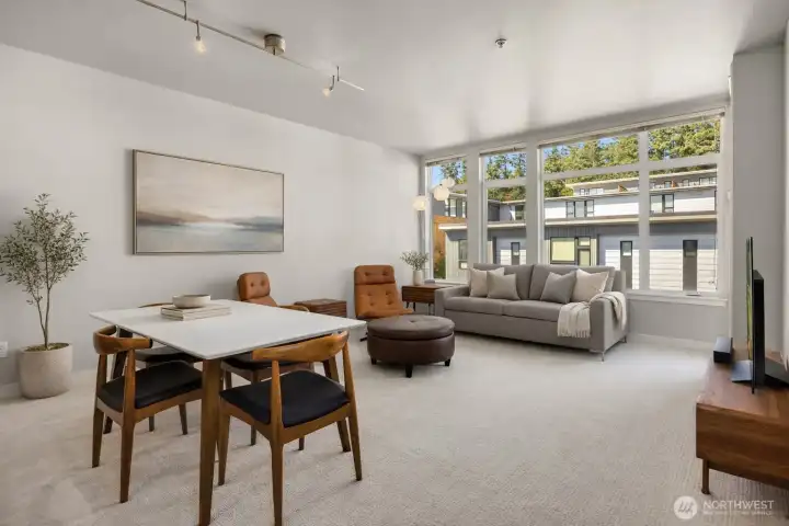 Large windows bring in beautiful natural light and enhance the home’s airy feel. Note: This image has some AI generated staging.