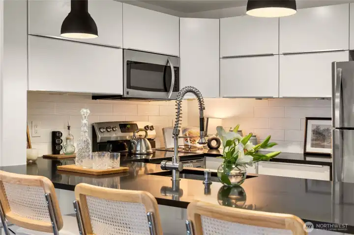 Stainless steel appliances & modern white cabinentry.