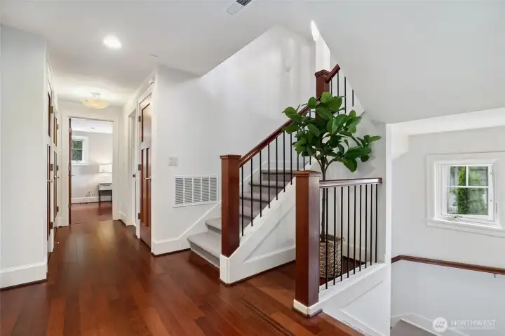 This is the landing between the bedroom level and the upstairs common area level. The gorgeous cherry and mahogany staircase and floors are warm and inviting. The staircase is light and bright with many large windows.