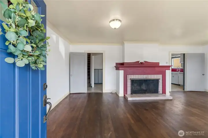 Enter into an open living room with original hardwoods and fireplace
