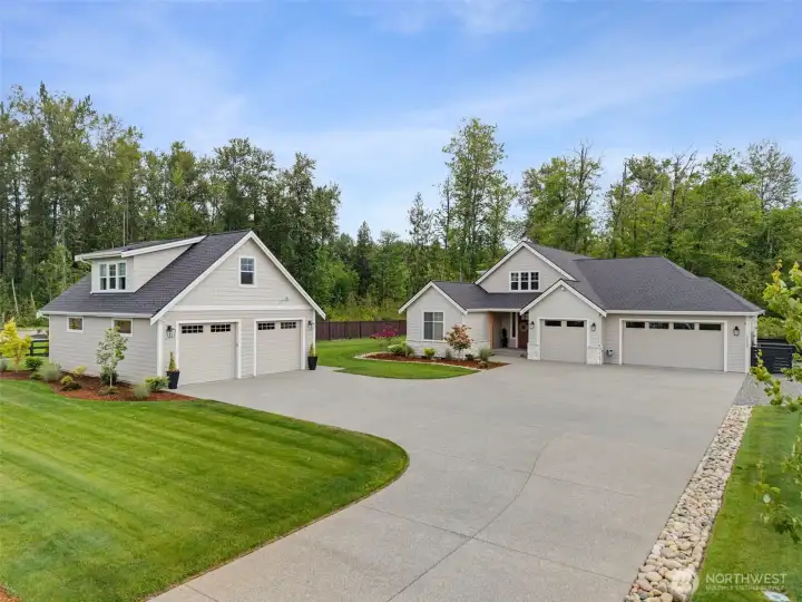 Set on a manicured lot with a sweeping concrete driveway, lush lawn, and mature evergreen privacy, this home offers both modern curb appeal and peaceful wooded surroundings.
