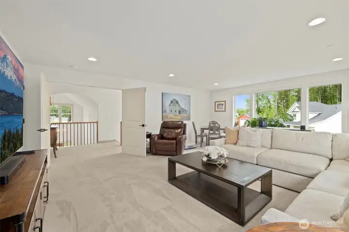 Spacious upstairs bonus room with vaulted ceilings and plush carpet. This versatile space is perfect as a media room, home office, or playroom, featuring abundant natural light and generous square footage.