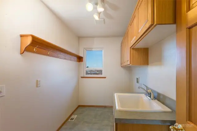 Laundry room with lots of cabinets and utility sink.