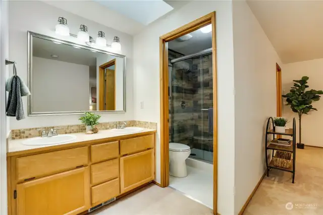 The primary suite has its own bathroom, spacious bedroom and a walk-in closet. There is plenty of storage, two sinks, a large picture mirror, and a refreshed shower, toilet and flooring in the primary bathroom.