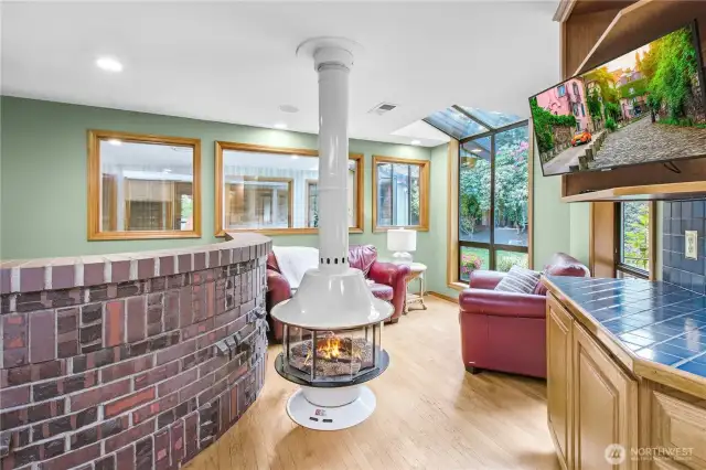 Comfortable seating area with gas fireplace next to kitchen prep area