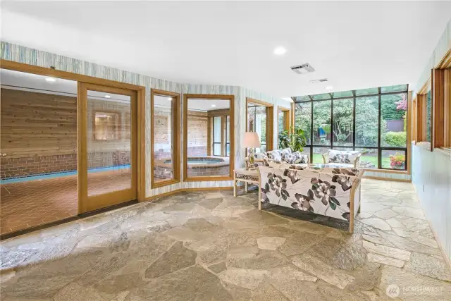 Scenic Pool Room Lounge: A comfortable sitting area thoughtfully positioned to offer captivating views of the sparkling indoor pool and the lush, beautifully landscaped backyard—an ideal spot to unwind and soak in the surroundings.
