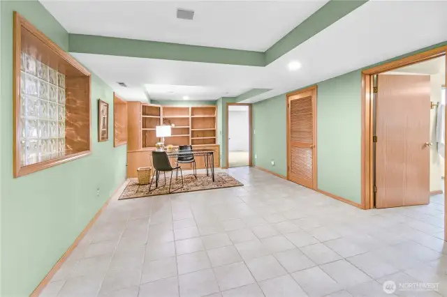 Versatile Lower-Level Flex Space: An expansive area perfect for a home office, creative studio, or cozy lounge, complete with custom built-in bookcases and cabinetry for stylish storage and organization.