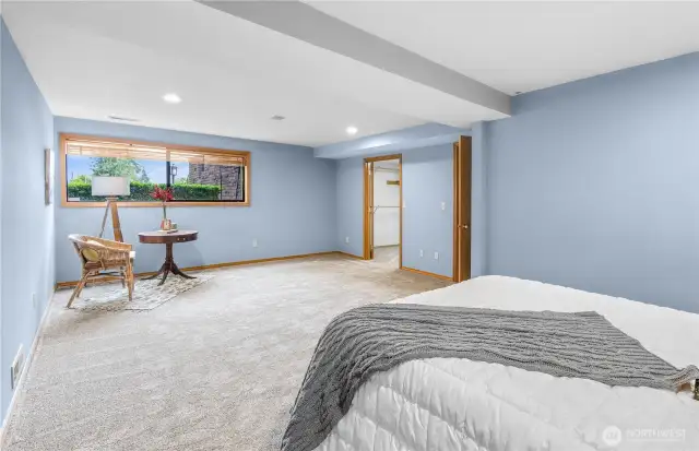Expansive Lower-Level Bedroom Retreat: A spacious haven featuring a comfortable sitting area, perfect for relaxation, reading, or creating a private lounging space.
