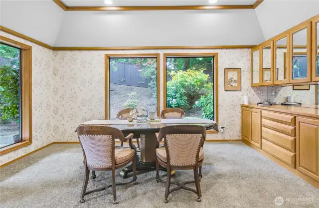 Elegant Formal Dining Room: A sophisticated space overlooking meticulously manicured landscaping, featuring a built-in china cabinet and additional lower storage cabinets—perfect for displaying treasured dinnerware and keeping essentials close at hand during gatherings.