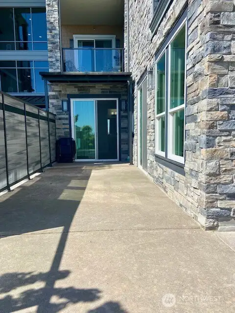 Primary bedroom has a slider that opens to the patio!  This is the side patio that also shows a portion of your privacy fence on the left.
