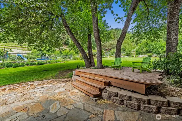 This tree-canopied deck is your personal sanctuary - perfect for morning coffee, afternoon reading, or evening conversations with the scent of summer in the air and the soft rustle of leaves overhead.