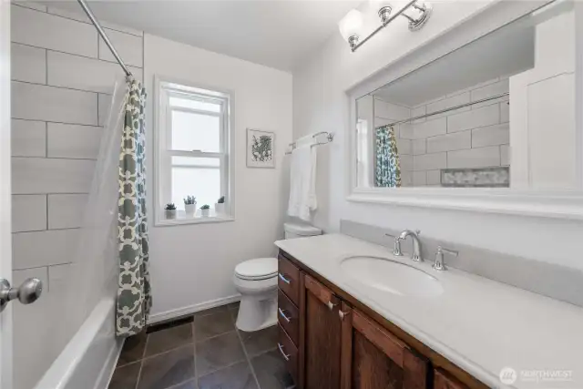 Stylish Tile Bath and Shower Combo Featuring a Large Vanity.