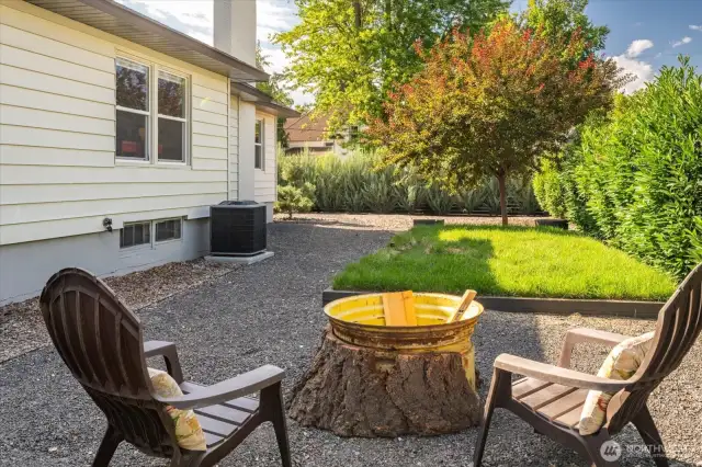 Backyard firepit with privacy hedge and grass