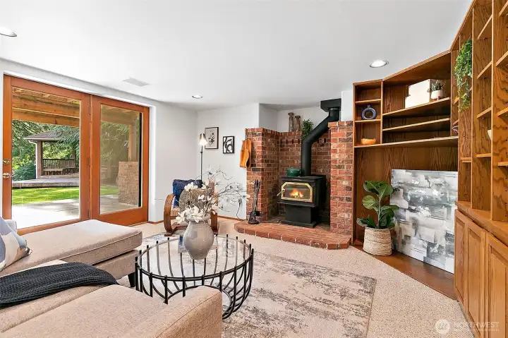 Basement rec room with cozy wood stove and built in cabinetry