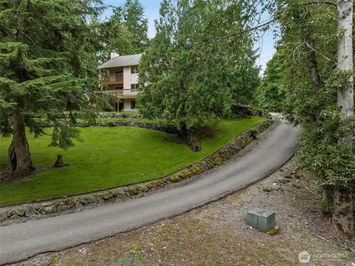 The long and graceful paved driveway is an enchanting approach to a magical setting
