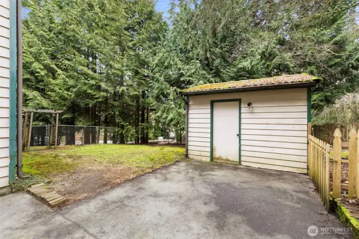 Outbuilding provides storage for lawn tools or lawn games.