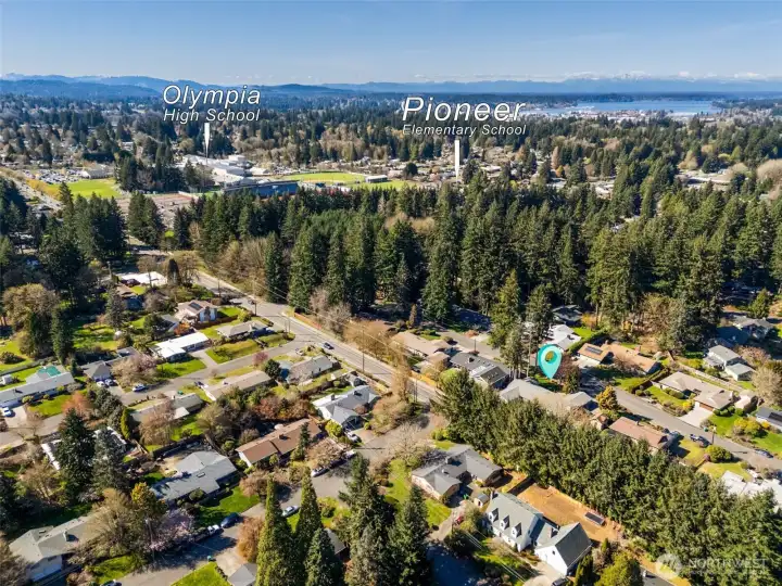From above, you start to see how connected this home is to everything that matters. Olympia High School and Pioneer Elementary are both right here, reinforcing that golden triangle location that’s so hard to find. There’s even a bit of nostalgia built in, with the sounds of Friday night football games and marching band music drifting through the neighborhood in the fall. In the distance, you can spot Budd Bay and the downtown waterfront, putting you within a quick drive of restaurants, markets, festivals, marina access, and all the local character Olympia is known for. It’s a location that lets you tap into the energy of the city, then come home to something quieter and more grounded.