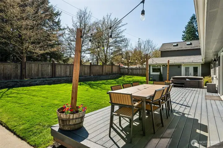 Right off the dining room slider, a generously sized composite deck gives you plenty of room to spread out with dining, lounging, or a full outdoor setup that doesn’t feel cramped. The composite material keeps things looking sharp with minimal upkeep, which means more time enjoying it and less time maintaining it. Just beyond, the hot tub is already in place and stays with the home, ready for evening unwinds or weekend resets. The yard itself is level, lush, and faces south, so it gets great sun throughout the day, perfect for lawn games, future garden beds, or just soaking up the light.