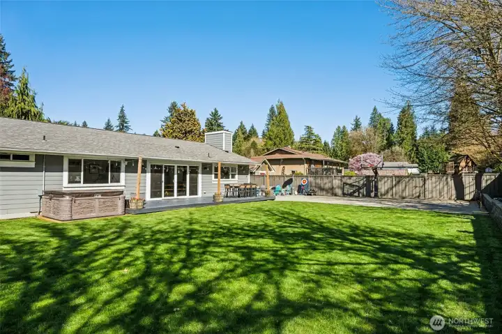 Sunlight filters through the mature trees beyond the fence, giving the yard that soft, dappled glow that feels especially good on warmer days. You can see the hot tub ready for evening resets, the sport court for a little friendly competition, and the composite deck set up for outdoor dining that actually gets used. With .3647 acres to work with, there’s still plenty of open lawn for soccer, football, or just letting things run free. And if inspiration strikes for your next project, both Home Depot and Lowe’s are under ten minutes away, which makes those weekend ideas a lot easier to pull off.