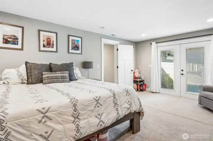 This is where the primary suite starts to feel like a true getaway. The glass double doors open right out to the back deck and hot tub, making it easy to step outside and unwind without going through the rest of the house. Built-in blinds between the glass panels let you control privacy in seconds, which is a great feature for a space like this. The room itself stays spacious and calm, with a large walk-in closet that adds plenty of storage. It’s a really nice blend of convenience, comfort, and a bit of that everyday luxury feel.