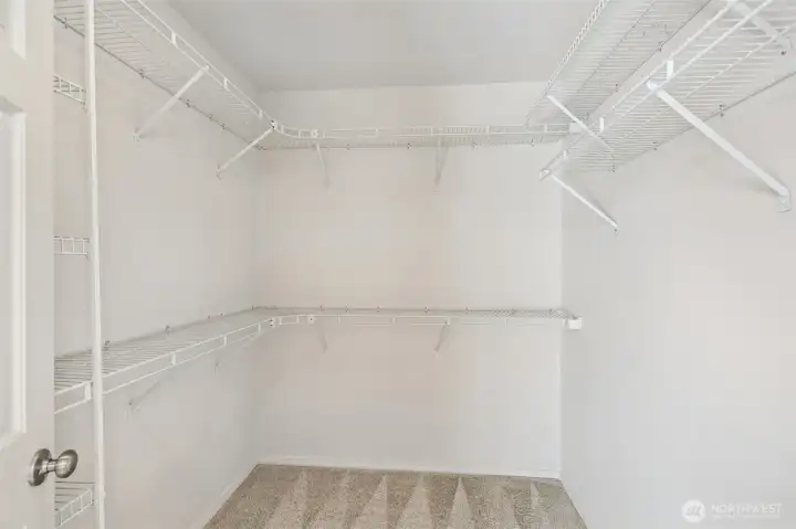 Large primary walk-in closet. Large primary walk-in closet.