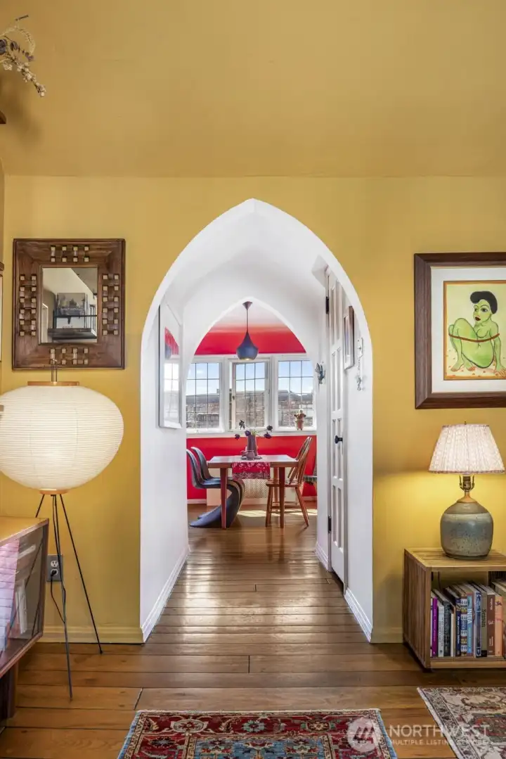 Arched hallway connects the living and dining spaces, showcasing the home’s signature Gothic-inspired architecture.