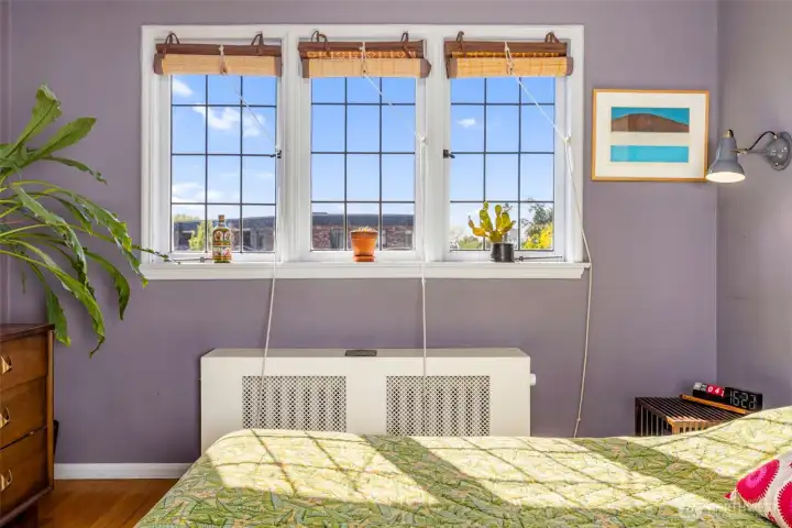Sun-filled bedroom windows bring in peaceful neighborhood views and beautiful natural light throughout the space.