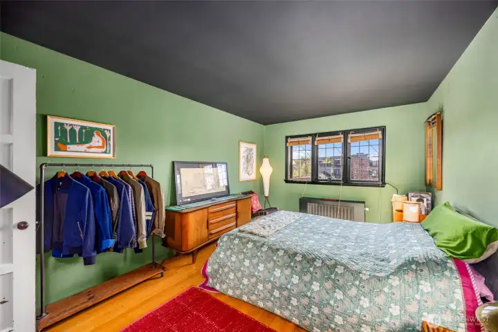 Spacious second bedroom bedroom with hardwood floors abundant natural light creating a cozy retreat.