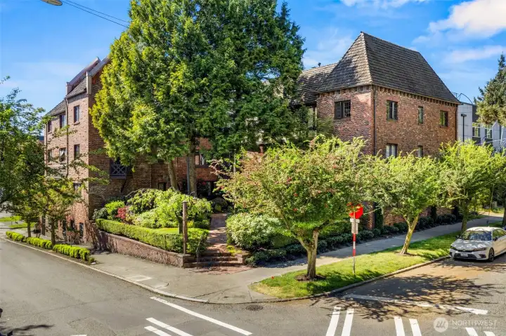 Iconic 1928 Anhalt building showcases timeless Tudor architecture, mature landscaping, and one of Seattle’s most beloved courtyard settings.