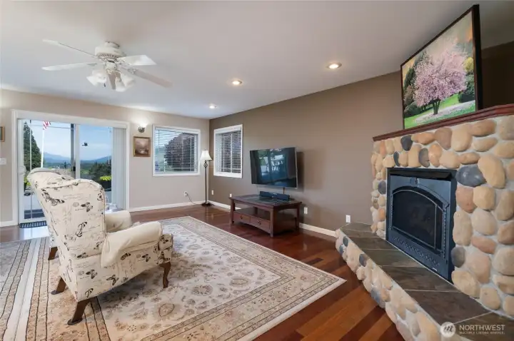 Open concept living room with great views and cozy river rock fireplace. Open concept living room with great views and cozy river rock fireplace.