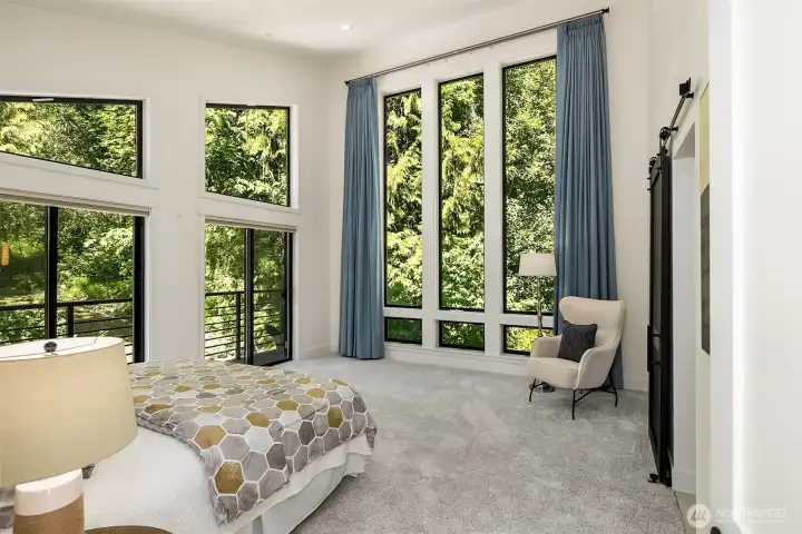 primary suite with deck and soaring windows