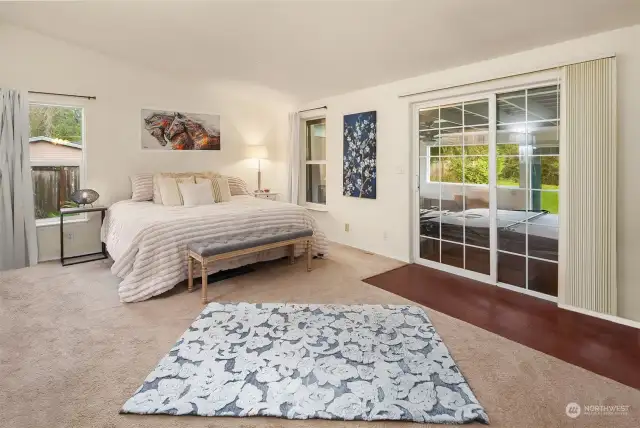 Primary bedroom with slider to hot tub and enclosed porch