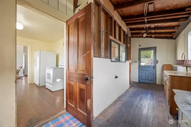 The back porch opens to the kitchen and has a lot of room for storage, but the kitchen could easily be extended into this area.