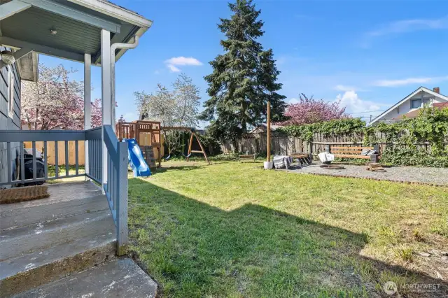 Exit the back of the home to your fenced backyard with cute fire pit and  playlet!