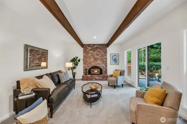 Bright and cheery family room with wood beamed ceiling and slider leading to huge entertainment deck.