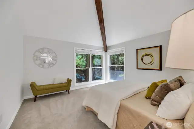 Primary suite bedroom has lots of light and great view of the wooded backyard - so private