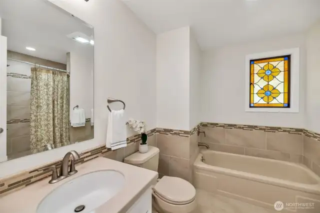 Updated primary four- piece bath with big walk-in shower and separate bathtub
