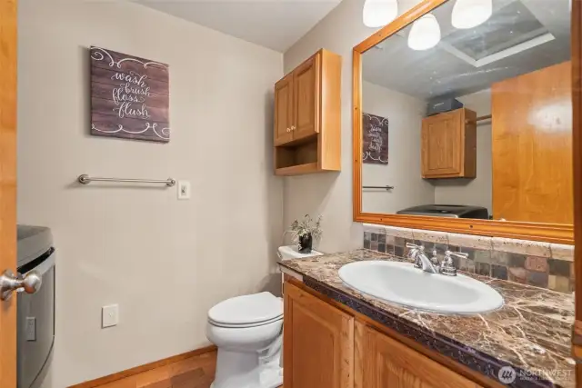 Main-level powder bath combined w/ utility space—smart layout offering function & convenience in one central spot.