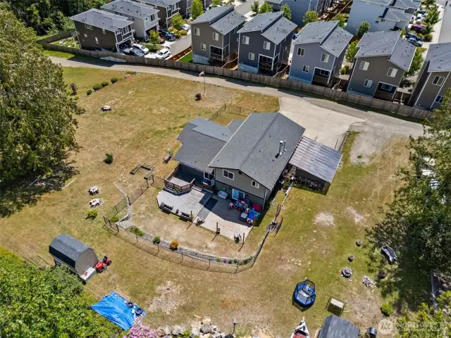 Aerial view showcases the full scale of the backyard & home—highlighting outdoor living space, layout, & surrounding privacy.