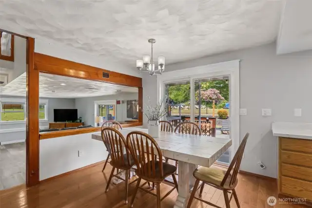 Dining room overlooks a step-down into the spacious lower-level living room—creating an open, connected feel across living spaces.