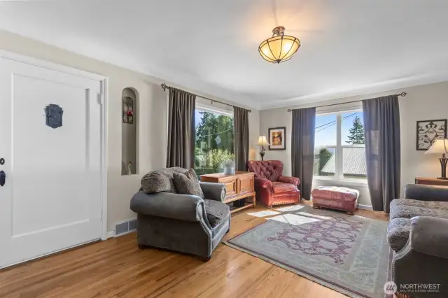 View of the living room and front entrance. Room has coved ceilings, oak flooring, and a lot of natural light.
