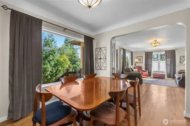 Dining room with picture window, coved ceilings, and oak  flooring.