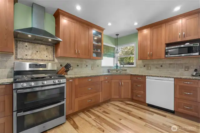 Updated kitchen w/cherry wood cabinetry, granite countertops, hickory flooring, and stainless appliances. View of the ADU and side yard/patio.