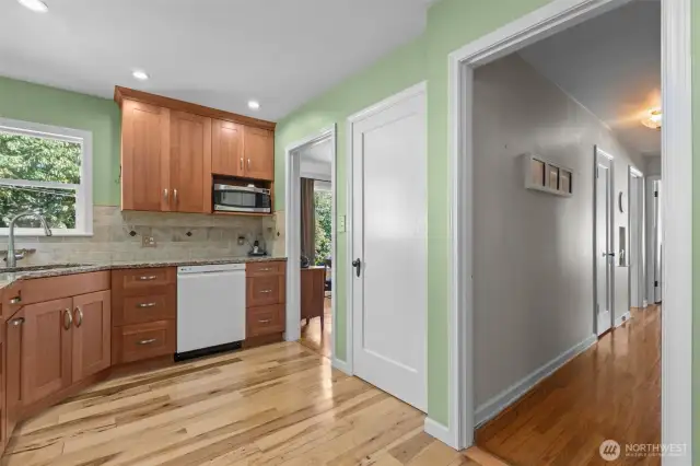 View of the kitchen leading to the hallway, basement, and dining room.
