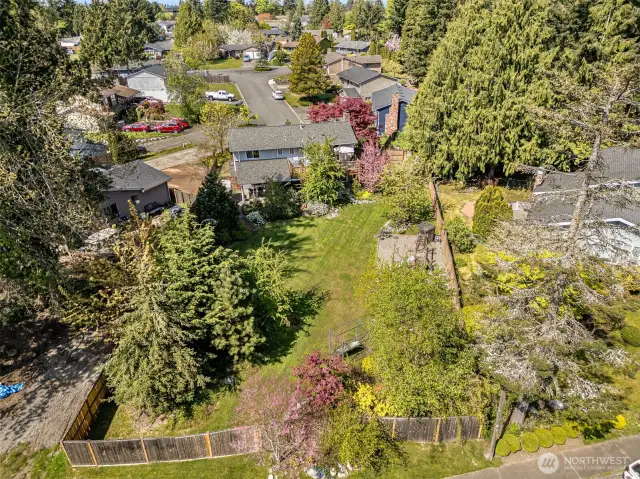Great aerial shot of the back of the home showcases the yard and surrounding greenery.