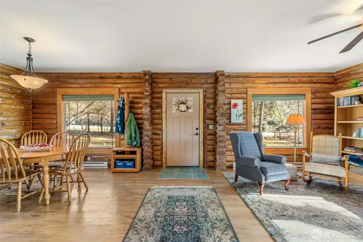 Great Room / Kitchen View -  Step inside to warm log walls, an inviting wood stove, and an open layout connecting the great room, kitchen, and dining—designed for easy living and cozy Chelan evenings year-round.